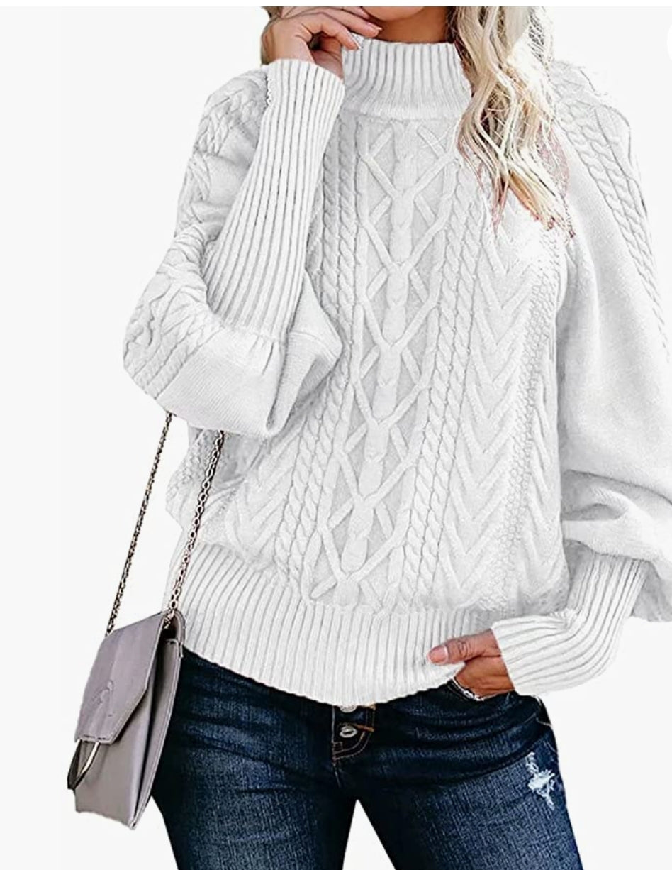 White cable knit balloon sleeve sweater/pullover on blonde woman standing on wall
